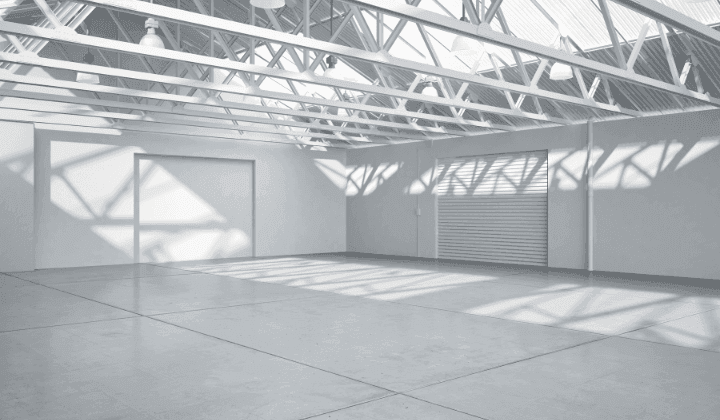 Interior of a single-storey steel building with triangulated roof trusses spanning a column-free floor
